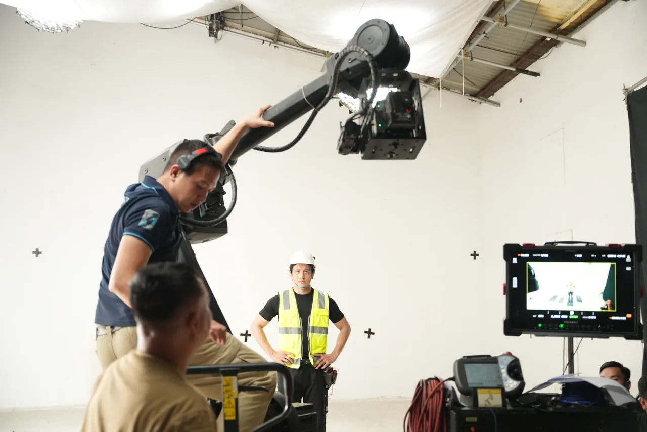Two crew steadying the camera head on the motion-control arm during a rig check