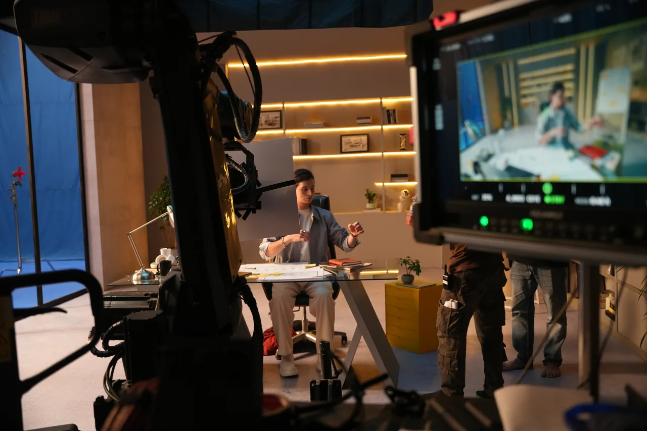 A blue screen at frame left, the lit set in the middle and the shot playing on the monitor at frame right