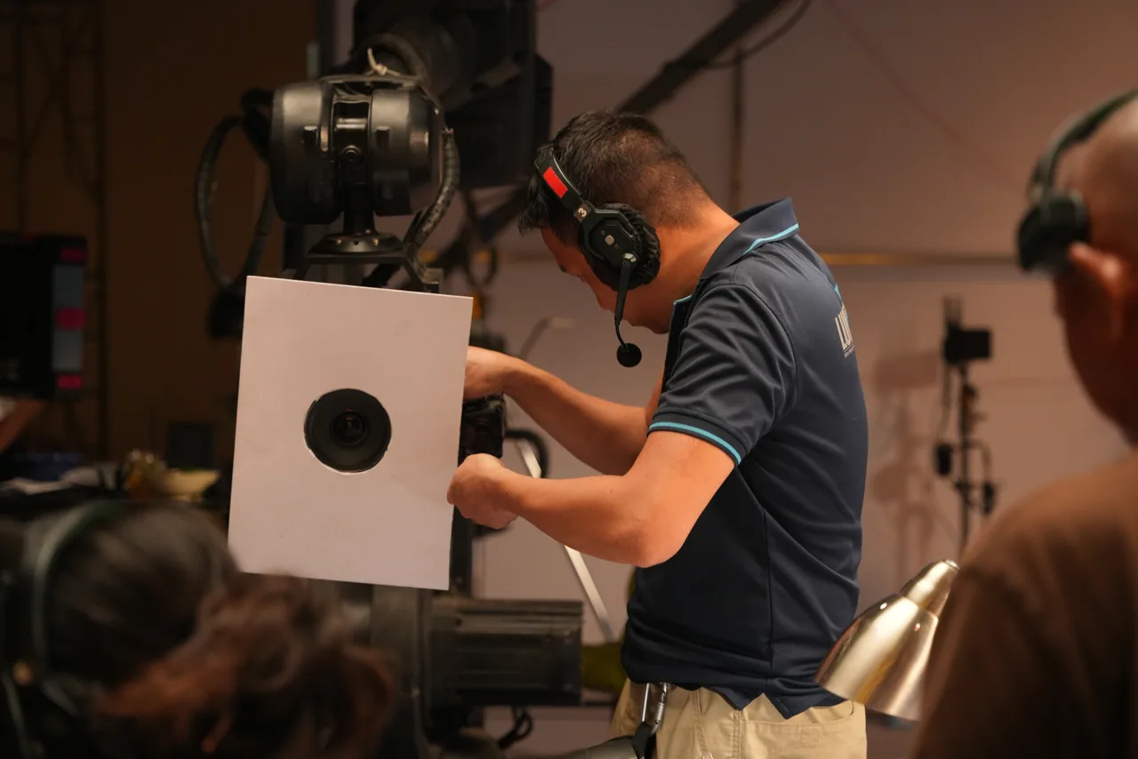 A focus chart held up to the lens while the operator racks the shot