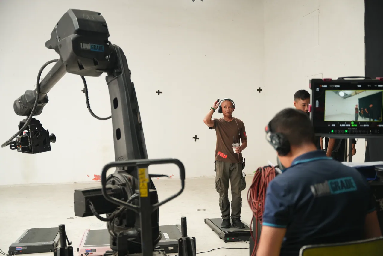 The 6-axis motion-control robot in profile on the studio floor, the crew watching the frame line up behind it