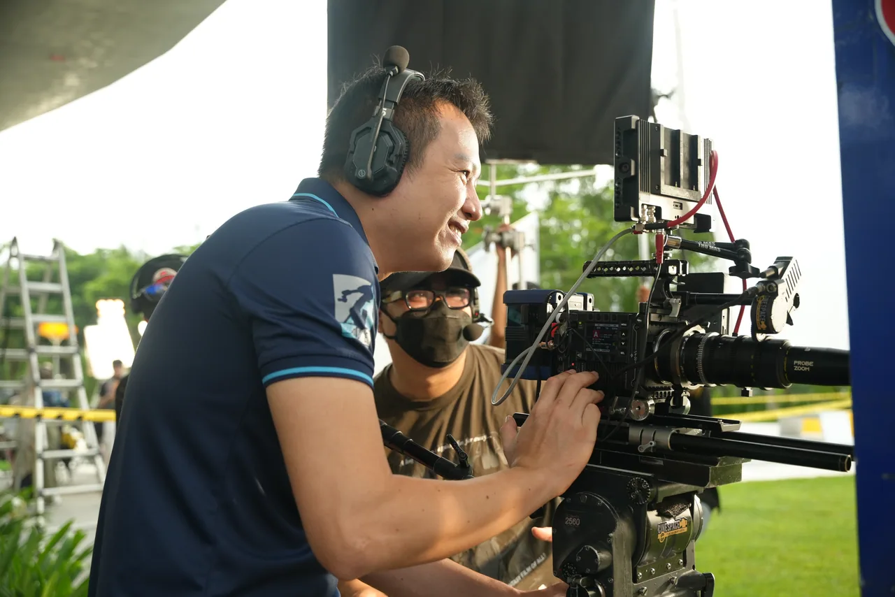 The operator lining up a shot behind the camera on location in daylight