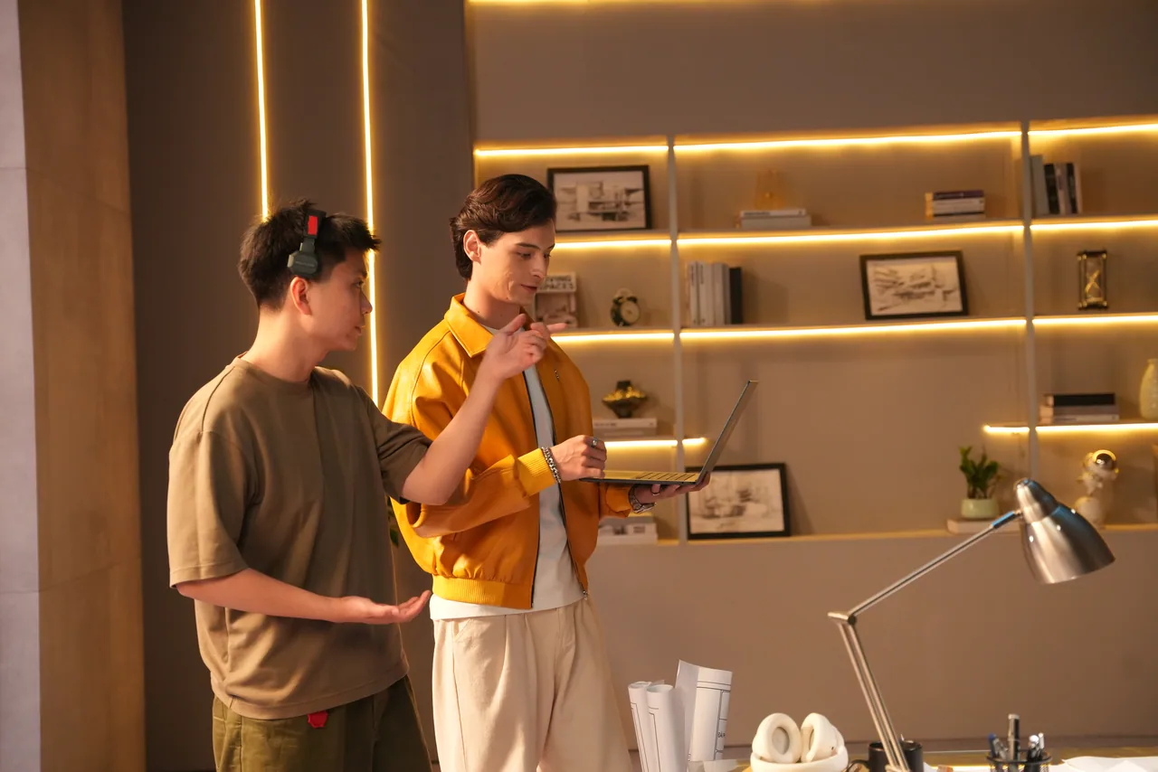 Two performers running a beat in front of the amber shelf wall