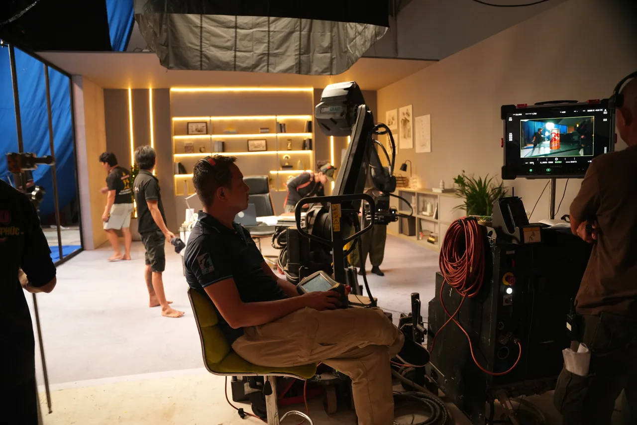 Video village on the apartment set: the operator at the cart, the blue screen wrapping behind